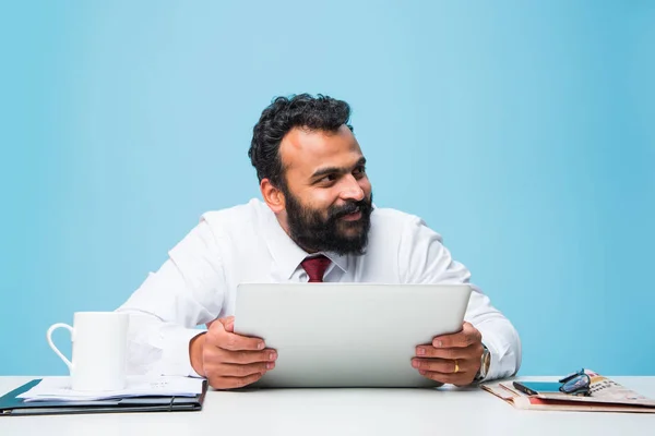 Bearded indian businessman holding tab or tablet pc with happy look while sitting at office table, asian business person holding touch pad — Stock Photo, Image