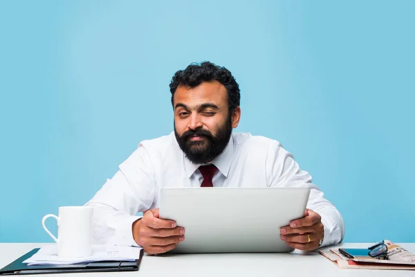 Bearded indian businessman holding tab or tablet pc with happy look while sitting at office table, asian business person holding touch pad — Stock Photo, Image
