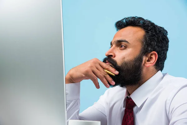 Frustrated indian young businessman with beard showing sad expressions in the office at computer table — Stock Photo, Image