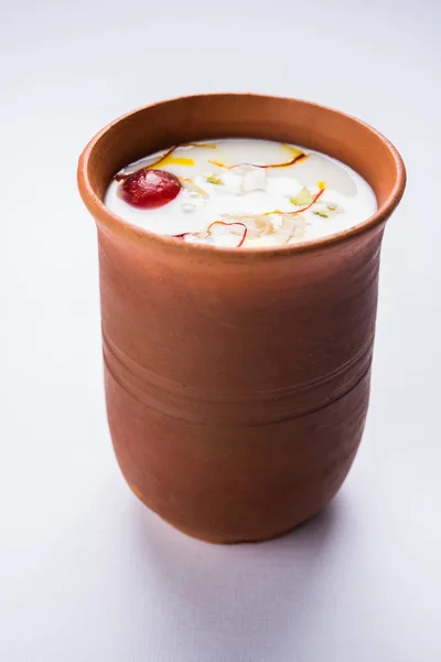 Authentic Indian cold drink made up of curd, milk & malai called Lassi in saffron / kesar flavour, also called kesariya or keshariya or kesar lassi, served in traditional indian terracotta glasses