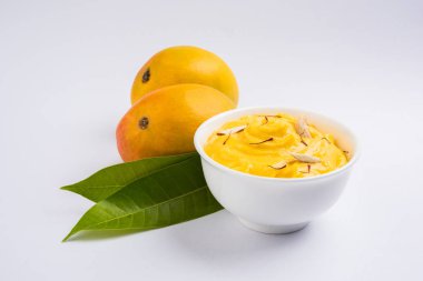 hapus veya alphonso Mango puding / Mango shrikhand veya srikhand veya amrakhand - Mango tatlı ile yoğunlaştırılmış süt magoes ve fındık, seçici odak üzerinde beyaz arka plan