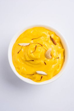 hapus veya alphonso Mango puding / Mango shrikhand veya srikhand veya amrakhand - Mango tatlı ile yoğunlaştırılmış süt magoes ve fındık, seçici odak üzerinde beyaz arka plan