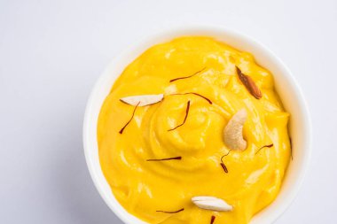 hapus veya alphonso Mango puding / Mango shrikhand veya srikhand veya amrakhand - Mango tatlı ile yoğunlaştırılmış süt magoes ve fındık, seçici odak üzerinde beyaz arka plan
