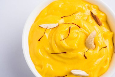 hapus veya alphonso Mango puding / Mango shrikhand veya srikhand veya amrakhand - Mango tatlı ile yoğunlaştırılmış süt magoes ve fındık, seçici odak üzerinde beyaz arka plan