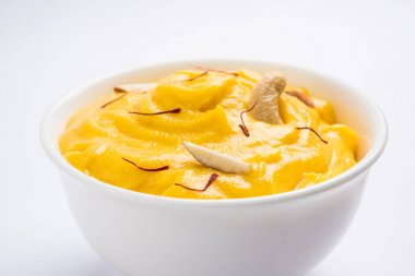 hapus veya alphonso Mango puding / Mango shrikhand veya srikhand veya amrakhand - Mango tatlı ile yoğunlaştırılmış süt magoes ve fındık, seçici odak üzerinde beyaz arka plan