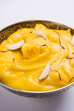 hapus veya alphonso Mango puding / Mango shrikhand veya srikhand veya amrakhand - Mango tatlı ile yoğunlaştırılmış süt magoes ve fındık, seçici odak üzerinde beyaz arka plan