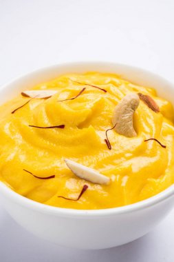 hapus veya alphonso Mango puding / Mango shrikhand veya srikhand veya amrakhand - Mango tatlı ile yoğunlaştırılmış süt magoes ve fındık, seçici odak üzerinde beyaz arka plan