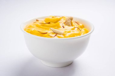 hapus veya alphonso Mango puding / Mango shrikhand veya srikhand veya amrakhand - Mango tatlı ile yoğunlaştırılmış süt magoes ve fındık, seçici odak üzerinde beyaz arka plan