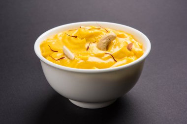 hapus veya alphonso Mango puding / Mango shrikhand veya srikhand veya amrakhand - Mango tatlı ile yoğunlaştırılmış süt magoes ve fındık, seçici odak üzerinde beyaz arka plan