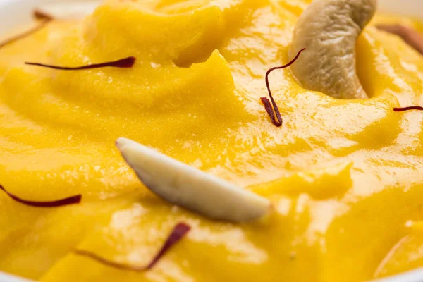 Hapus o alphonso Pudín de mango / Mango shrikhand o srikhand o amrakhand - Postre de mango con magos de leche condensada y frutos secos, enfoque selectivo sobre fondo blanco — Foto de Stock