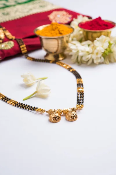 Nærbilde av en Mangalsutra eller et smykke som skal bæres av gifte hindu-kvinner, med tradisjonell saree eller paithani med huldi kumkum og mogra-blomster eller Jasminum sambac garland – stockfoto