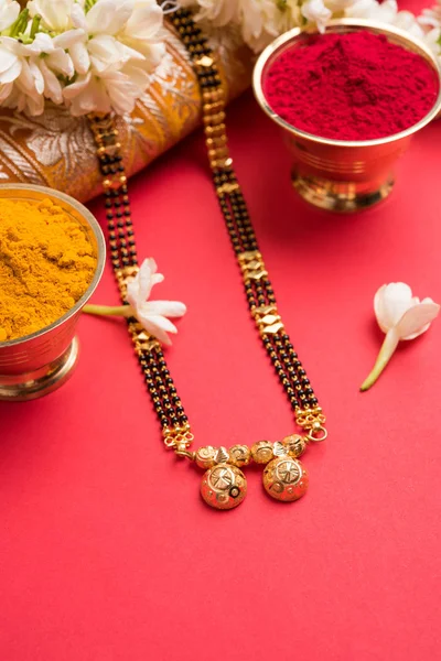 Foto de cerca de un Mangalsutra o collar para llevar por una mujer hindú casada, con saree tradicional o paithani con flores de huldi kumkum y mogra o guirnalda de sambac de jazmín — Foto de Stock