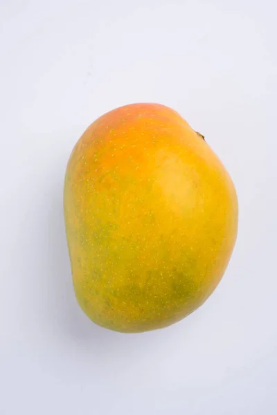 König der Früchte; alphonso gelbe Mango-Frucht-Duo mit Stielen und grünem Blatt isoliert auf weißem Hintergrund in einem Korb aus Zuckerrohr, ein Produkt von Konkan aus Maharashtra - Indien — Stockfoto