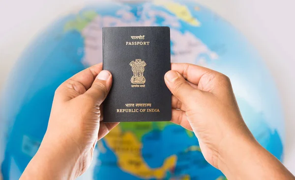 Closeup picture of indian man holding indian passport over white background, selective focus — Stock Photo, Image