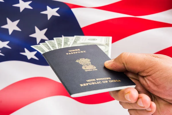 concept showing Indian passport with US currency notes or Dollars with american flag in the background, applying for US / american tourist or H-1B visa