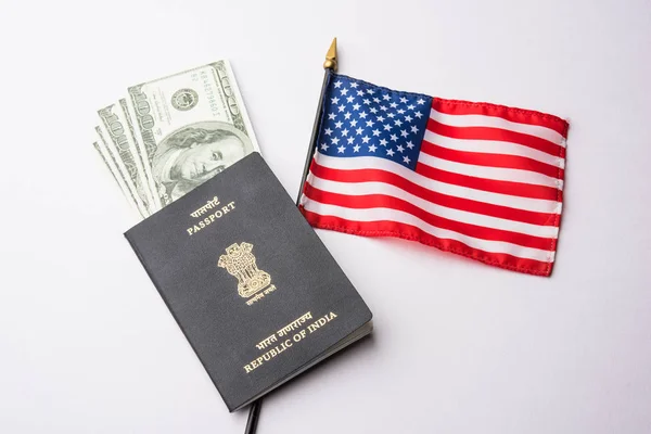 concept showing Indian passport with US currency notes or Dollars with american flag in the background, applying for US / american tourist or H-1B visa