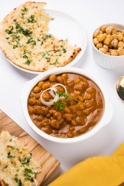 Baharatlı piliç bezelye köri veya Çola Masala veya Chana Masala veya chole bhature veya choley dilimlenmiş soğan ve yeşil kişniş yaprağı, seçici odak ile süslenmiş