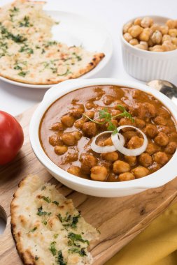 Baharatlı piliç bezelye köri veya Çola Masala veya Chana Masala veya chole bhature veya choley dilimlenmiş soğan ve yeşil kişniş yaprağı, seçici odak ile süslenmiş