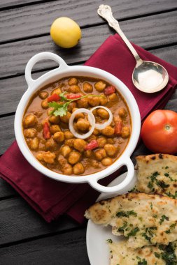 Baharatlı piliç bezelye köri veya Çola Masala veya Chana Masala veya chole bhature veya choley dilimlenmiş soğan ve yeşil kişniş yaprağı, seçici odak ile süslenmiş