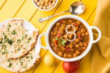 Baharatlı piliç bezelye köri veya Çola Masala veya Chana Masala veya chole bhature veya choley dilimlenmiş soğan ve yeşil kişniş yaprağı, seçici odak ile süslenmiş