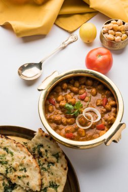 Baharatlı piliç bezelye köri veya Çola Masala veya Chana Masala veya chole bhature veya choley dilimlenmiş soğan ve yeşil kişniş yaprağı, seçici odak ile süslenmiş