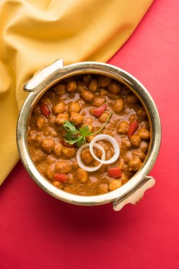 Baharatlı piliç bezelye köri veya Çola Masala veya Chana Masala veya chole bhature veya choley dilimlenmiş soğan ve yeşil kişniş yaprağı, seçici odak ile süslenmiş