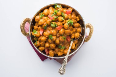 Baharatlı piliç bezelye köri veya Çola Masala veya Chana Masala veya chole bhature veya choley dilimlenmiş soğan ve yeşil kişniş yaprağı, seçici odak ile süslenmiş