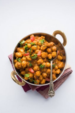 Baharatlı piliç bezelye köri veya Çola Masala veya Chana Masala veya chole bhature veya choley dilimlenmiş soğan ve yeşil kişniş yaprağı, seçici odak ile süslenmiş