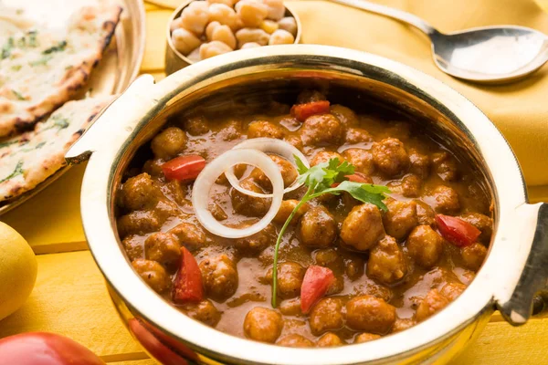 Baharatlı piliç bezelye köri veya Çola Masala veya Chana Masala veya chole bhature veya choley dilimlenmiş soğan ve yeşil kişniş yaprağı, seçici odak ile süslenmiş