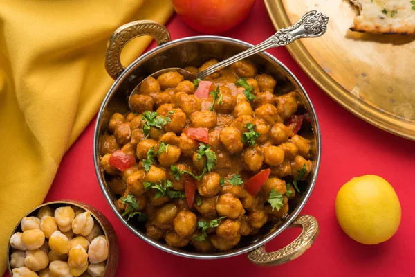Baharatlı piliç bezelye köri veya Çola Masala veya Chana Masala veya chole bhature veya choley dilimlenmiş soğan ve yeşil kişniş yaprağı, seçici odak ile süslenmiş