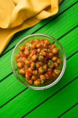 Baharatlı piliç bezelye köri veya Çola Masala veya Chana Masala veya chole bhature veya choley dilimlenmiş soğan ve yeşil kişniş yaprağı, seçici odak ile süslenmiş