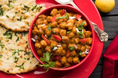 Baharatlı piliç bezelye köri veya Çola Masala veya Chana Masala veya chole bhature veya choley dilimlenmiş soğan ve yeşil kişniş yaprağı, seçici odak ile süslenmiş