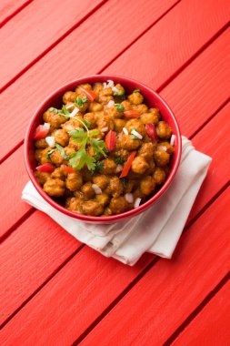Baharatlı piliç bezelye köri veya Çola Masala veya Chana Masala veya chole bhature veya choley dilimlenmiş soğan ve yeşil kişniş yaprağı, seçici odak ile süslenmiş