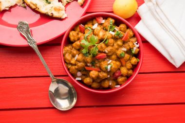 Baharatlı piliç bezelye köri veya Çola Masala veya Chana Masala veya chole bhature veya choley dilimlenmiş soğan ve yeşil kişniş yaprağı, seçici odak ile süslenmiş