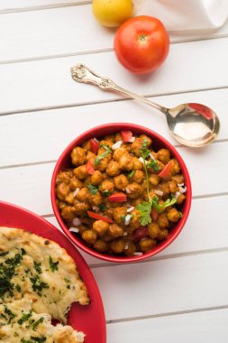 Baharatlı piliç bezelye köri veya Çola Masala veya Chana Masala veya chole bhature veya choley dilimlenmiş soğan ve yeşil kişniş yaprağı, seçici odak ile süslenmiş