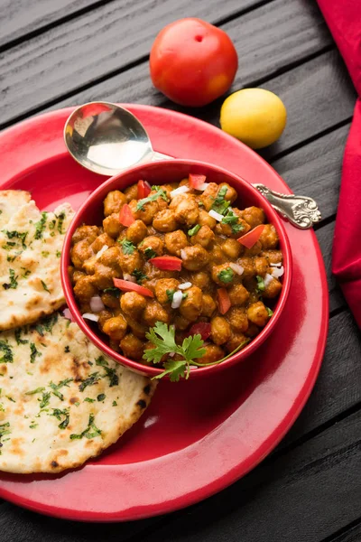 Baharatlı piliç bezelye köri veya Çola Masala veya Chana Masala veya chole bhature veya choley dilimlenmiş soğan ve yeşil kişniş yaprağı, seçici odak ile süslenmiş — Stok fotoğraf