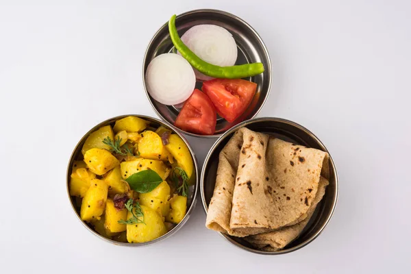 Hint tipik paslanmaz çelik öğle yemeği kutusu veya tiffin chapati gibi Kuzey Hint veya maharashtrian yemek menüsü ile / / roti, dal tadka, beyaz pirinç ve aloo / patates sabji / gobi veya karnabahar sabji salatası ile — Stok fotoğraf