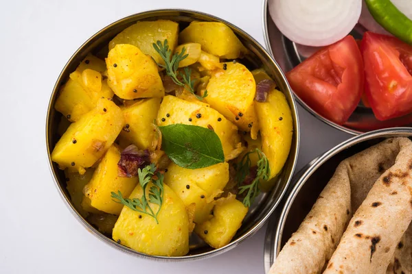 Indiska typiska rostfri matlåda eller tiffin med norr Indiska eller maharashtrian matmeny som chapati / / roti, dal tadka, vitt ris och aloo / potatis sabji / gobi eller blomkål sabji med sallad — Stockfoto