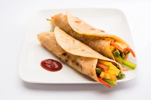 Indian popular snack food called Vegetable spring rolls or veg roll or veg franky made using paneer or cottage cheese and vegetables wrapped inside paratha/chapati/roti with tomato ketchup — Stock Photo, Image