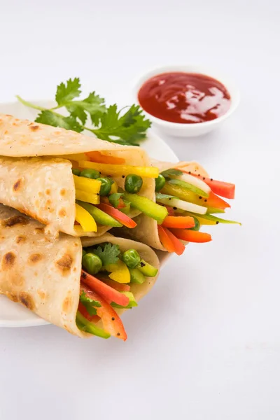 Indian popular snack food called Vegetable spring rolls or veg franky made using vegetables wrapped inside paratha/chapati/roti with tomato ketchup