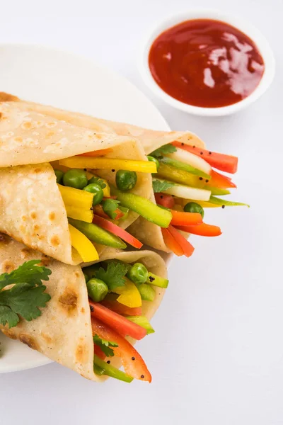 Indian popular snack food called Vegetable spring rolls or veg franky made using vegetables wrapped inside paratha/chapati/roti with tomato ketchup