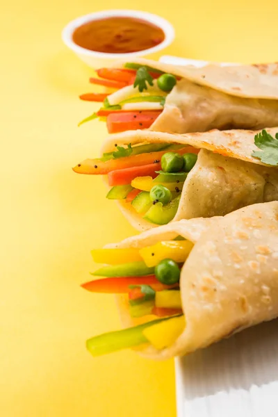 Collation populaire indienne appelée rouleaux de printemps aux légumes ou légumes franky à base de légumes enveloppés à l'intérieur de paratha / chapati / roti avec ketchup tomate — Photo