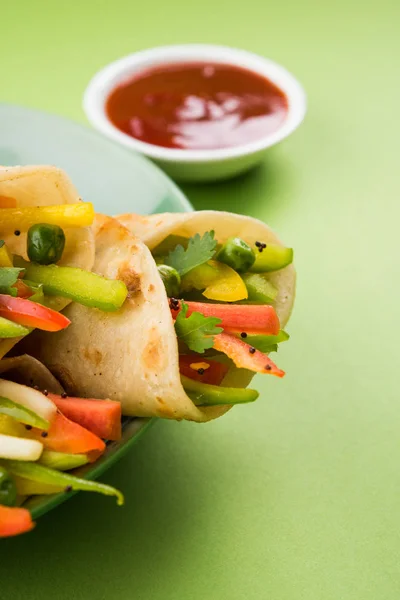 Indian popular snack food called Vegetable spring rolls or veg franky made using vegetables wrapped inside paratha/chapati/roti with tomato ketchup