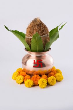 Bakır kalash Hindistan cevizi ve mango yaprak çiçek dekorasyonu ile. hindu puja, düz arka plan üzerinde seçici odak uçucu