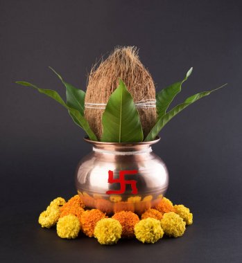 Bakır kalash Hindistan cevizi ve mango yaprak çiçek dekorasyonu ile. hindu puja, düz arka plan üzerinde seçici odak uçucu