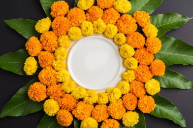 kadife çiçeği veya zendu çiçek ve mango kullanılarak yapılan çiçek rangoli kopya alanı orta, seçici odak ile siyah arka plan üzerinde bırakır