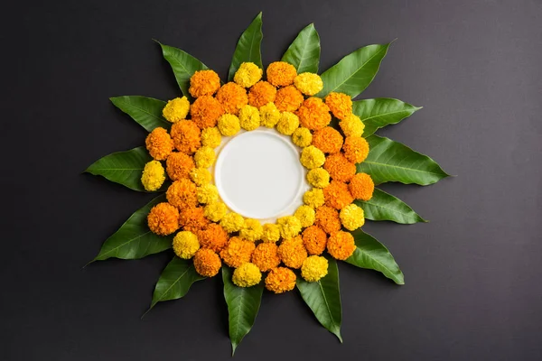 kadife çiçeği veya zendu çiçek ve mango kullanılarak yapılan çiçek rangoli kopya alanı orta, seçici odak ile siyah arka plan üzerinde bırakır