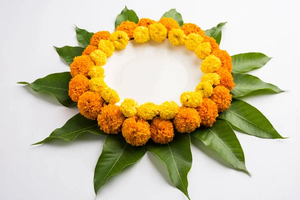 Rangoli bunga dibuat menggunakan bunga marigold atau zendu dan daun mangga di atas latar belakang hitam dengan ruang fotokopi di tengah, fokus selektif — Stok Foto