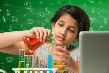 Çocuklar ve bilim kavramı - sevimli Hint küçük kız meşgulken bilim veya kimya tüp ve Emanet göz cam şişeye yeşil kara tahta arka plan üzerinde çizilmiş bilim karalamalar ile denemek