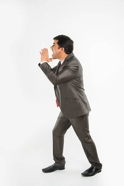 Indiana jovem empresário gritando ou anunciando algo em voz alta em felicidade sobre fundo branco — Fotografia de Stock